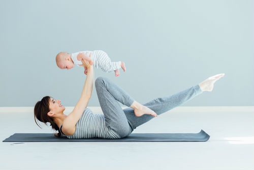 mujer haciendo pilates con su hijo